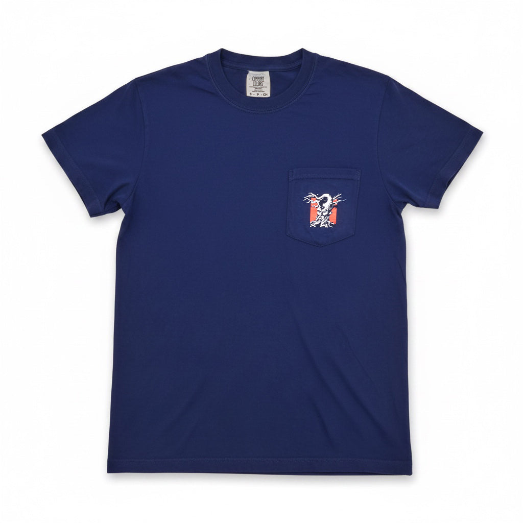 A blue crewneck tee shirt with a pocket .The pocket has the Angry Orchard Tree logo against a red square. The shirt is laid flat against a white background. 