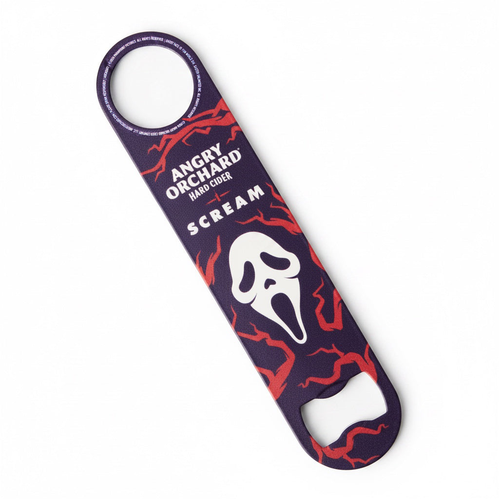 A bottle opener featuring a design from the movie 'Scream' with the 'Angry Orchard' brand logo, showing a white Ghostface mask on a dark purple background with red lightning patterns, set against a plain white background.